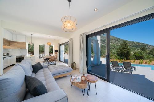 a living room with a couch and a large window at Diosas Luxury Villas in Pilaroú