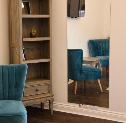 a mirror in a room with two chairs and a table at Upstairs at 33 - Self check in boutique accommodation in Worcester Centre in Worcester