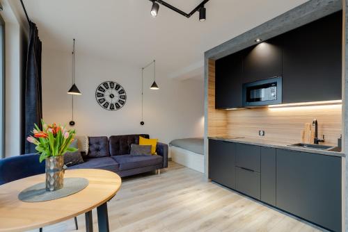 een keuken en een woonkamer met een bank en een tafel bij Grey Horse Apartments in Gdańsk
