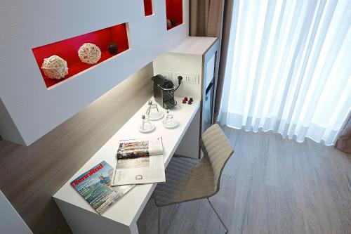 a room with a desk with a book and a chair at Enjoy Garda Hotel in Peschiera del Garda