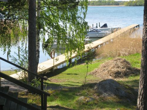 a boat is docked at a dock on a lake at Stenslid Bottna By St Anna in Söderköping