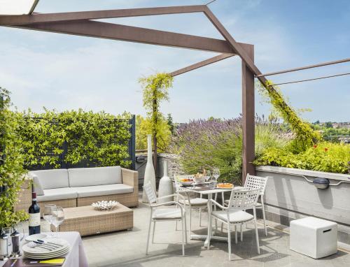 a patio with a couch and a table and chairs at Enjoy Garda Hotel in Peschiera del Garda