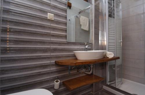 a bathroom with a sink and a glass shower at IATROU HOUSE- villa WITH INCREDIBLE VIEW in Portariá