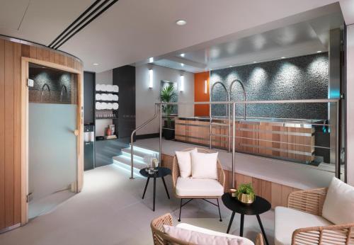 a lobby with a waiting area with chairs and tables at The Athenaeum Hotel & Residences in London