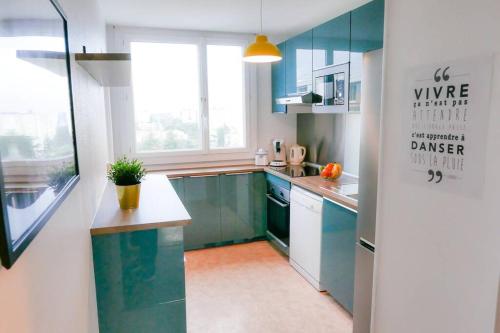 une cuisine avec des placards bleus et une grande fenêtre dans l'établissement Vue dégagée Pyrénées Pau - 3 chambres 6 pers- Parking Gratuit, à Pau