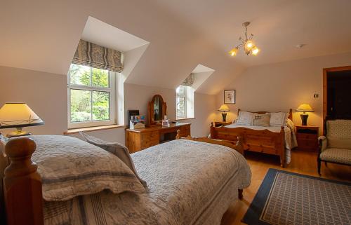 um quarto com duas camas e uma cadeira. em Lis-Ardagh Lodge em Union Hall