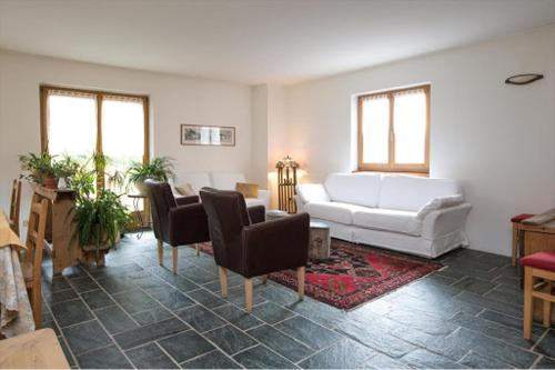 ein Wohnzimmer mit einem weißen Sofa und Stühlen in der Unterkunft B&B Cecilia in Valfurva