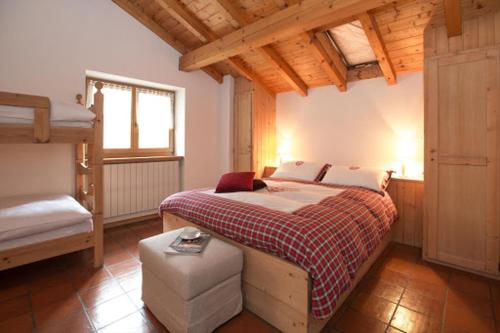 ein Schlafzimmer mit einem Bett und einer Bank darin in der Unterkunft B&B Cecilia in Valfurva