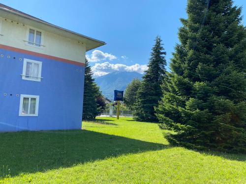 a house with a tree next to a building at ibis budget Albertville in Gilly-sur-Isère