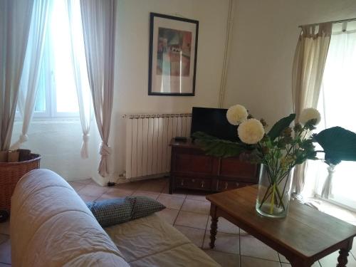 a living room with a vase of flowers on a table at Le Mas de Baraud in Villeneuve-de-Berg