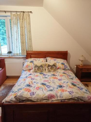 a bed with a comforter with butterflies on it at Agrojelonki Agroturystyka in Gietrzwałd