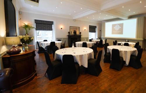 a conference room with tables and chairs and a screen at Gwydyr Hotel in Betws-y-coed