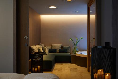 a living room with a couch and a sink at Infinity Hotel & Conference Resort Munich in Unterschleißheim