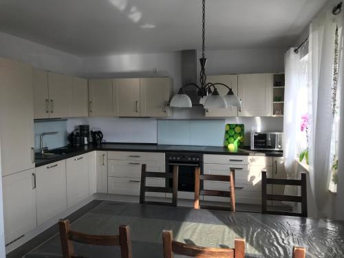a kitchen with white cabinets and a table and chairs at Ferienhaus Nahe der Ostsee in Bad Doberan