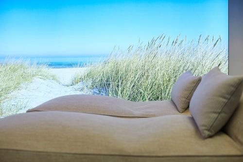 a couch sitting on the sand at the beach at Infinity Hotel & Conference Resort Munich in Unterschleißheim