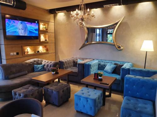 a living room with blue couches and a tv at Family Apartments in Zaječar