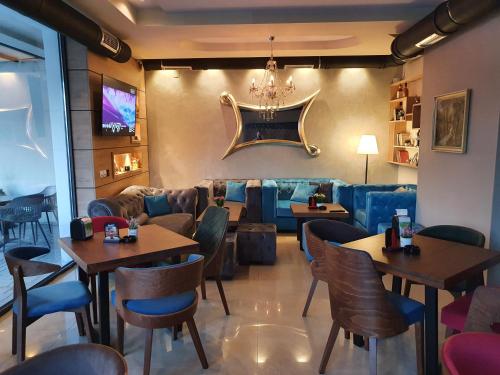 a restaurant with tables and chairs and a couch at Family Apartments in Zaječar