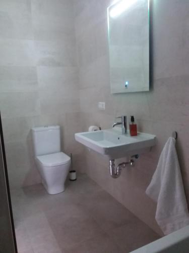 a bathroom with a sink and a toilet and a mirror at Casa Clavero in Ronda