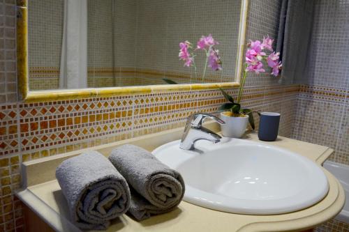 a bathroom with a sink and a mirror and towels at VILA CRISTINA MAR (8 guests and oceanview) in Albufeira