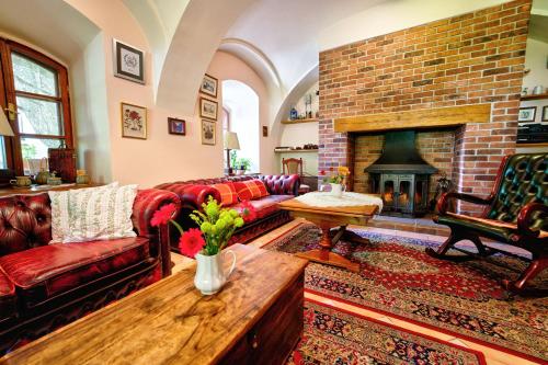 a living room with red couches and a fireplace at Penzion Onyx in Český Krumlov