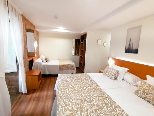 a hotel room with two beds and a couch at Hostal Anosa Casa in Santiago de Compostela