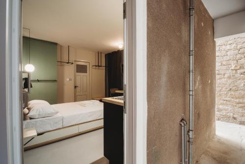 a small bedroom with a bed and a bathroom at eins rooms - city center in Limassol