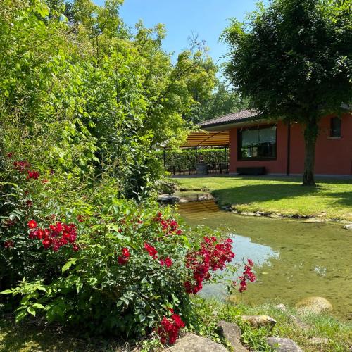 a garden with red flowers and a house at Il Leone D'Oro in Telgate