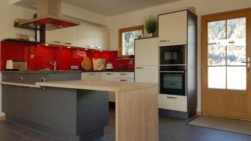 cocina con paredes rojas y encimera de madera en Houghton Haus, en Mallnitz