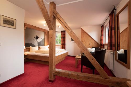 a hotel room with a bed and a staircase at Hotel-Gasthof Der Wiesengrund in Bad Hindelang