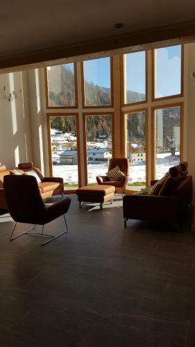 a large room with couches and chairs and windows at Houghton Haus in Mallnitz