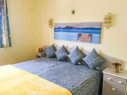 a bedroom with a blue bed with blue pillows at Primavera in Portimão