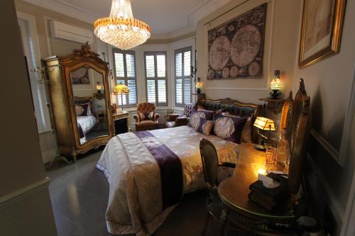 um quarto com uma cama, uma mesa e um lustre em Tower Guest House em York