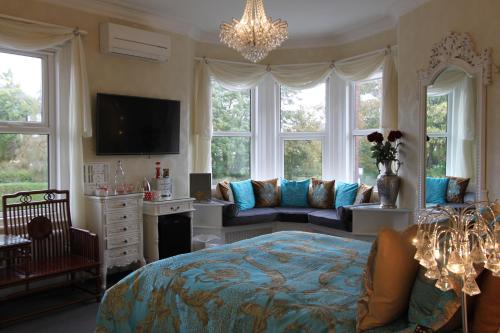 a bedroom with a bed and a couch and windows at Tower Guest House in York