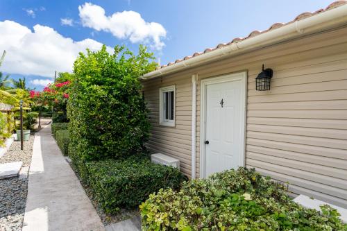 aige house with a white door and bushes at South Coast Horizon in Curtain Bluff