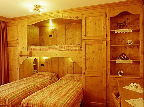 two bunk beds in a room with wooden walls at Agriturismo Prati Oitzinger in Valbruna