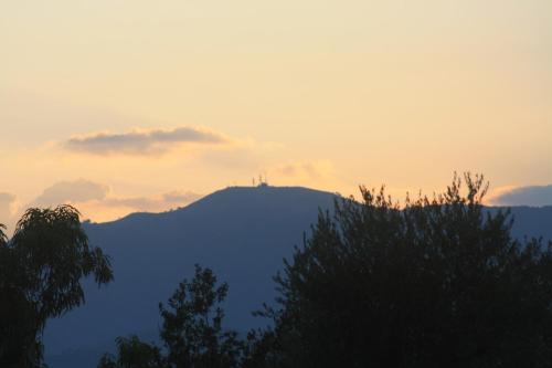 a view of a mountain with the sun setting at La Quercia Agriturismo in Imperia
