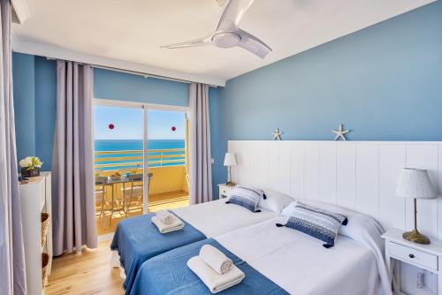sypialnia z łóżkiem i widokiem na ocean w obiekcie Sur suites stella maris w mieście Fuengirola