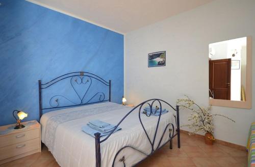 Un dormitorio con una cama con una pared azul. en Casa Sarina, en San Vito lo Capo