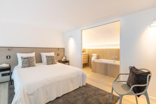 - une chambre avec un lit, une chaise et une baignoire dans l'établissement B1 Loft Duplex 175Blo-Paris Convention, à Paris