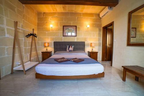 a bedroom with a large bed in a stone wall at Sant Anton tal-Qabbieza Farmhouse in Kerċem
