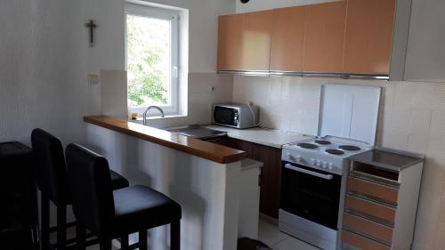 uma pequena cozinha com fogão e micro-ondas em Home Padovan em Rab