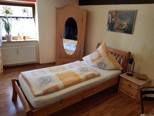 a bedroom with a bed and a dresser and a window at Zum Burgtörle in Walldürn