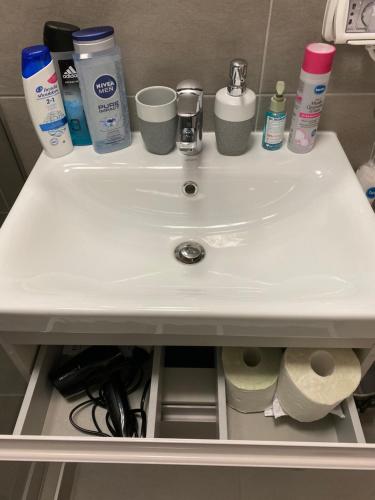a bathroom sink with toilet paper and other items on it at Take PRO Timisoara Apartment in Timişoara