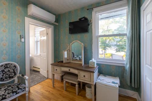 a room with a vanity with a mirror and a window at Prince Street Suites in Charlottetown