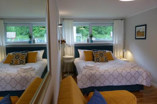 a bedroom with two beds and a mirror at Apartamenty BB nad Kryniczanką in Krynica Zdrój