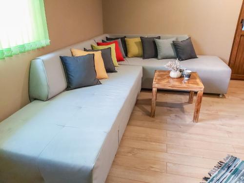 uma sala de estar com um sofá com almofadas e uma mesa em Апартамент Св. Антоний Велики Apartment St. Anthony the Great em Sandanski