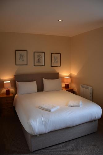 ein Schlafzimmer mit einem großen weißen Bett mit zwei Lampen in der Unterkunft Killarney Country Club in Faha
