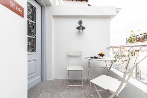 a small balcony with a table and a chair at SKIA-Cosy Living in Skiathos Town