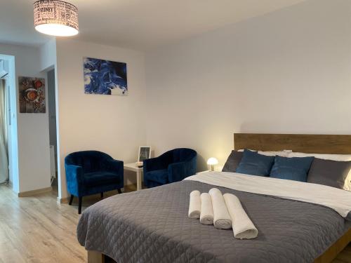 a bedroom with a large bed with blue pillows at Take PRO Timisoara Apartment in Timişoara
