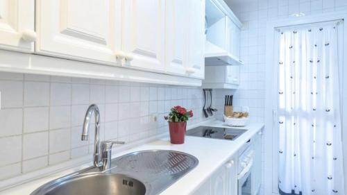 a kitchen with a sink and white cabinets at MI CAPRICHO 3-5 BEACHFRONT- Apartment with sea views in Costa del Sol in Mijas Costa